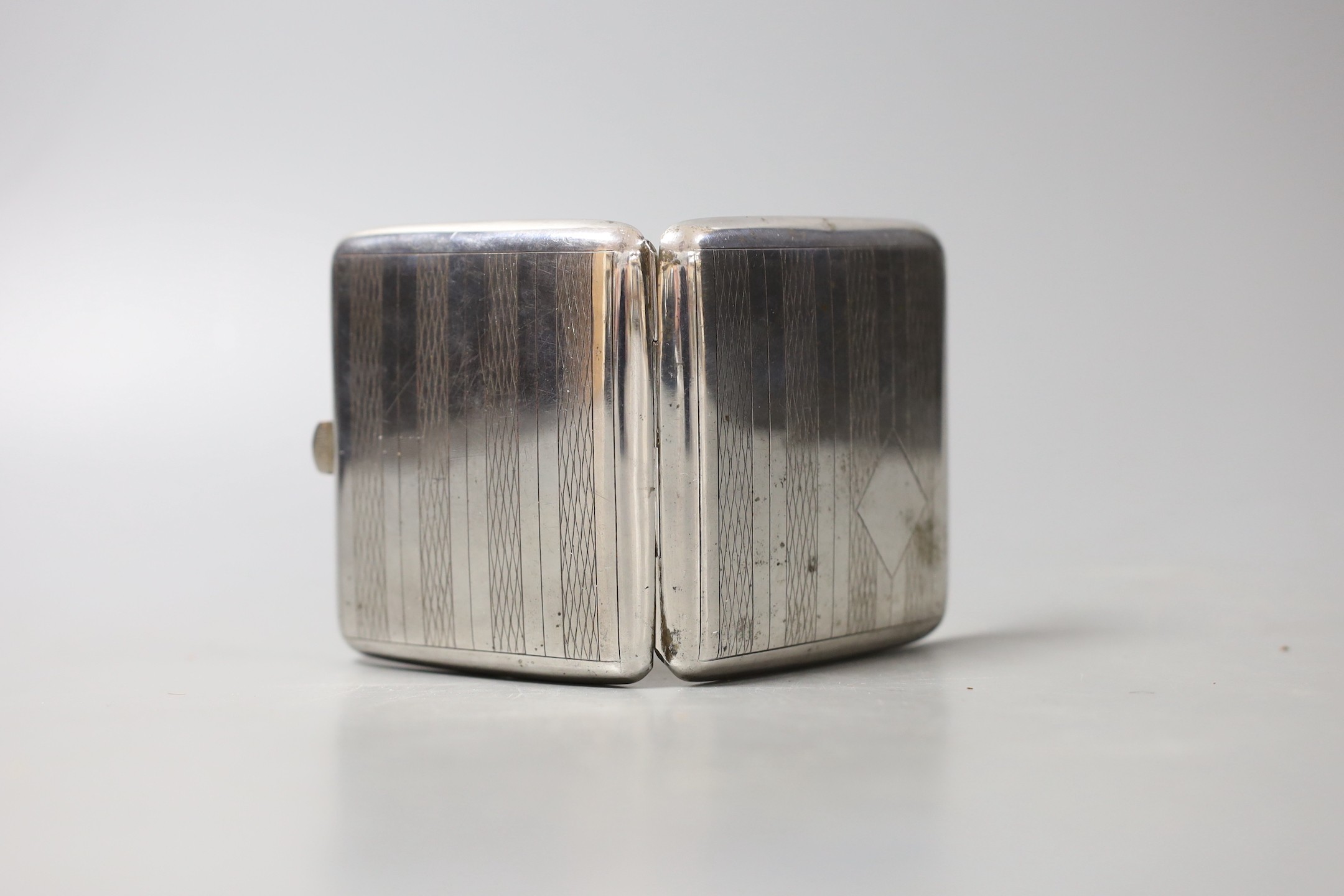 A white metal cigarette case and small silver including a pair of salts, condiment and napkin ring.